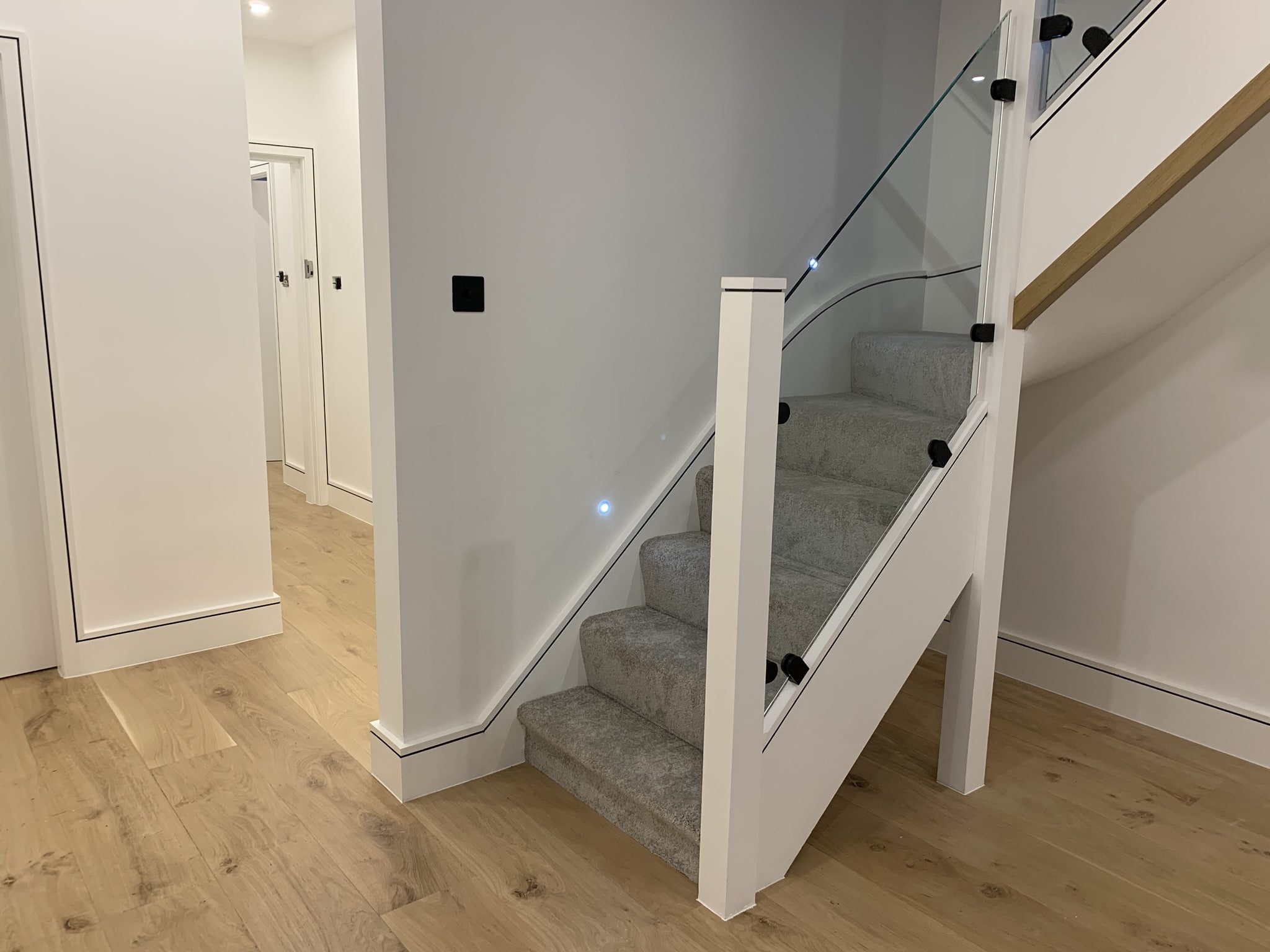 Staircase with carpet cover and toughened safety glass balustrade.
