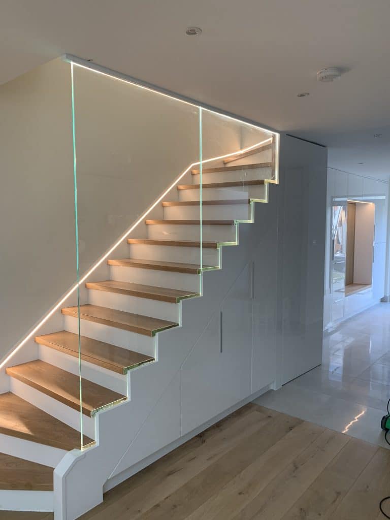 Staircase with storage. Safety 12mm glass banister with LED lights.