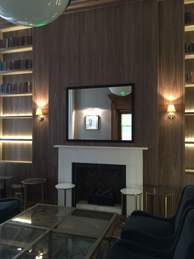 Fireplace with walnut chimney cladding and bookshelves.